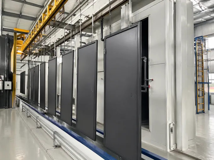 Automated powder coating line showing 5-stage pre-treatment process for architectural steel doors