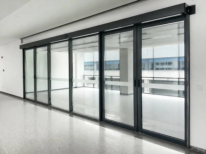 EUWOO sliding commercial door — top-hung aluminum configuration in a commercial corridor