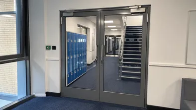Glass fire door at school corridor junction providing supervision visibility