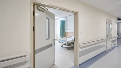 Interior fire doors in hospital ward corridor and school stairwell high-traffic compartmentation