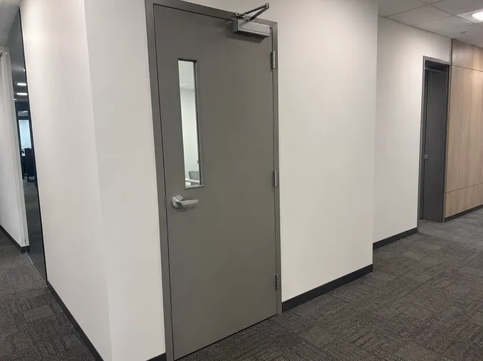 Office fire door installed in corporate corridor — powder coat finish, vision panel, FD60 rated