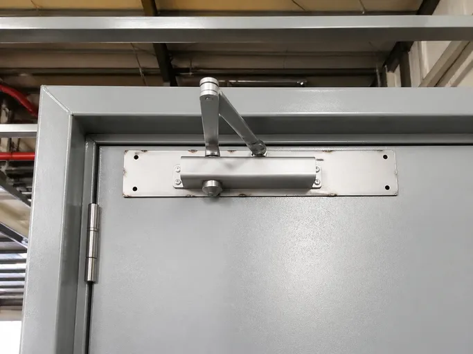 Welded 3mm backing plate on steel fire door closer mounting position before powder coating