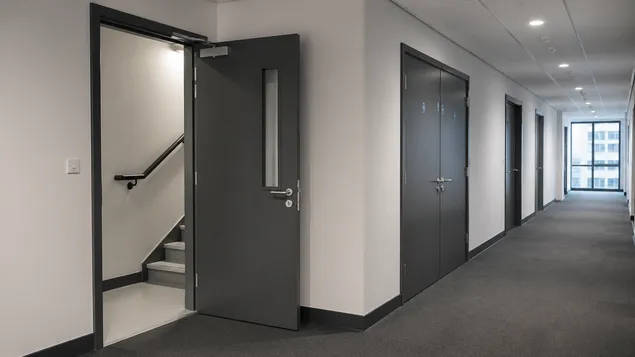 Self closing fire doors installed in commercial office corridor