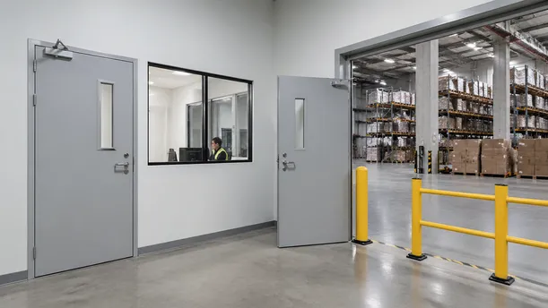 Security doors at warehouse office-to-floor transition and controlled access zone in distribution center