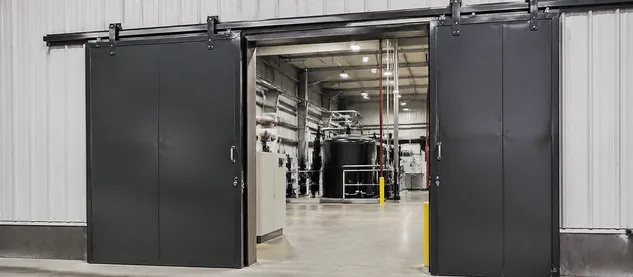 Heavy-duty sliding security door for industrial manufacturing plant zone separation