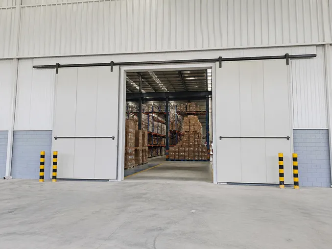 Sliding security door installed at a warehouse loading bay showing parallel wall movement