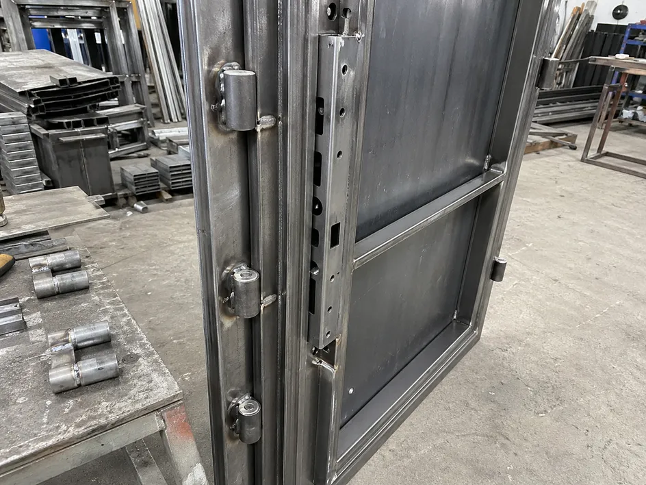 Steel security door lock zone reinforcement channel and hinge plate welding detail