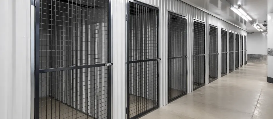Row of wire mesh security doors installed in a self-storage facility showing standardized unit fit-out