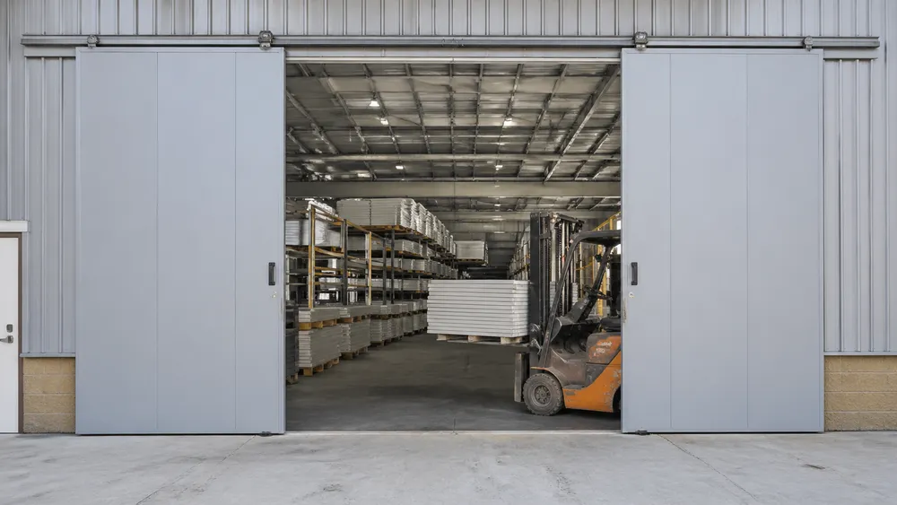 Warehouse steel door configured for loading dock and forklift clearance