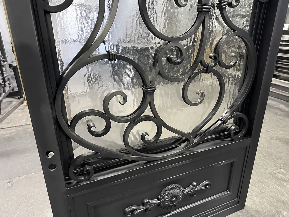 Close-up of EUWOO iron door scrollwork and panel insert detail showing in-house fabrication quality